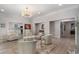 Bright living room featuring white armchairs, a decorative chandelier, and wood-look flooring at 1015 Bedford Gardens Dr, Alpharetta, GA 30022