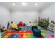 Spacious playroom with colorful alphabet rug, slide, and storage for books and toys at 1015 Bedford Gardens Dr, Alpharetta, GA 30022