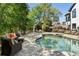 Backyard with an in-ground pool, stone patio, and ample seating area with outdoor furniture at 1015 Bedford Gardens Dr, Alpharetta, GA 30022