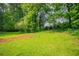 View of a large, green backyard with lush grass and surrounded by mature trees, perfect for outdoor activities at 2020 Buckingham Ct, Decatur, GA 30035