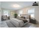 Digitally staged bedroom with bed, chair, and natural light at 2020 Buckingham Ct, Decatur, GA 30035