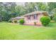 Well-manicured lawn and landscaping accentuates this delightful brick single-Gathering home at 2020 Buckingham Ct, Decatur, GA 30035