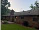 Brick home with a patio, well maintained lawn, and mature trees in a peaceful, wooded backyard at 2020 Buckingham Ct, Decatur, GA 30035