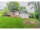 Lush backyard with deck, brick home, fire pit, and steps leading to an upper level at 2814 Brackenwood Dr, Snellville, GA 30039