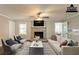 Bright living room with a brick fireplace, ceiling fan, and large windows for natural light at 2814 Brackenwood Dr, Snellville, GA 30039