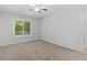 A bedroom with a ceiling fan, a window overlooking trees, and a door to the side at 3500 Stonewall Pl, Atlanta, GA 30339