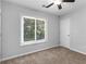 A serene bedroom with a ceiling fan and a window view of lush green trees at 3500 Stonewall Pl, Atlanta, GA 30339