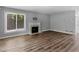 Open living room has a fireplace, large window, and beautiful floors at 3500 Stonewall Pl, Atlanta, GA 30339