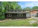 View of home's rear exterior featuring a covered patio and a lush, green yard surrounded by mature trees at 446 Waterford Nw Rd, Atlanta, GA 30318