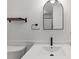 Contemporary bathroom featuring black fixtures, an arched mirror, modern vanity, and a sleek design at 579 Fielding Ln, Atlanta, GA 30311