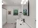 Elegant bathroom featuring white hexagon tile flooring, a wooden vanity, black fixtures, and modern lighting at 579 Fielding Ln, Atlanta, GA 30311