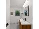 Stylish bathroom showcasing a wooden vanity, black hardware, white hexagon tile flooring, and modern lighting at 579 Fielding Ln, Atlanta, GA 30311