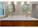 Updated bathroom featuring a double vanity, a wood cabinet, and gold fixtures beneath modern mirrors at 579 Fielding Ln, Atlanta, GA 30311