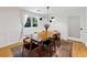 Bright dining room features hardwood floors, modern chandelier, a wooden table with stylish chairs, and bright window at 579 Fielding Ln, Atlanta, GA 30311