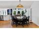 Open dining room with hardwood floors, a modern light fixture, and views of the living room and greenery outside at 579 Fielding Ln, Atlanta, GA 30311