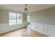 Dining room featuring hardwood floors, wainscoting, large window, and modern lighting at 1316 Durham Ter, Mcdonough, GA 30252