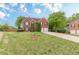 Spacious front yard view of a two-story brick home with a two-car garage and mature trees at 1316 Durham Ter, Mcdonough, GA 30252
