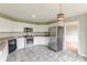 Open kitchen with white cabinets, granite countertops, stainless steel appliances, and tile flooring at 1316 Durham Ter, Mcdonough, GA 30252