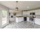 Bright kitchen with white cabinets, granite countertops, stainless steel appliances, and tile flooring at 1316 Durham Ter, Mcdonough, GA 30252