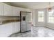 Bright kitchen with white cabinets, granite countertops, and stainless steel appliances, adjacent to the breakfast nook at 1316 Durham Ter, Mcdonough, GA 30252