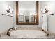 Luxurious bathtub featuring granite surround, vintage fixtures, and ornate lighting at 1431 Waterford Green Dr, Marietta, GA 30068