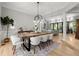 Elegant dining room featuring a modern chandelier, rustic wood table, and views into the backyard at 1431 Waterford Green Dr, Marietta, GA 30068