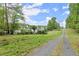 View of the back of the home and the gravel road between the back of the property and the treeline at 1431 Waterford Green Dr, Marietta, GA 30068