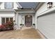 Exterior view of home with an attached garage, front door, and mature rose bushes at 1431 Waterford Green Dr, Marietta, GA 30068