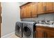 Modern laundry room features stainless steel appliances, wooden cabinets, and granite countertop at 1431 Waterford Green Dr, Marietta, GA 30068