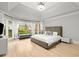 Bright and airy main bedroom featuring tray ceiling, hardwood floors, and many windows at 1431 Waterford Green Dr, Marietta, GA 30068