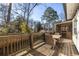 Back deck featuring an outdoor dining area with a wooden railing and a peaceful backyard view at 1598 Olympian Sw Cir, Atlanta, GA 30310