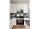 Modern kitchen with stainless steel appliances, white cabinets, and stylish gray backsplash at 1598 Olympian Sw Cir, Atlanta, GA 30310