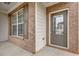 Close up shot of the brick porch and glass-paneled front door at 209 Woodmill Sw Way, Atlanta, GA 30331