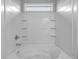 Bright tub-shower combination featuring white tile, built-in shelves and shower head at 209 Woodmill Sw Way, Atlanta, GA 30331