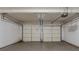 Spacious two car garage with white doors, opener on ceiling, and concrete floor at 4995 Panola Mill Dr, Lithonia, GA 30038