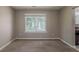 Neutral walled living room with a carpeted floor and a large window overlooking the backyard at 4995 Panola Mill Dr, Lithonia, GA 30038