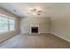 Spacious living room with plush carpet, fireplace, ceiling fan, and a large window at 4995 Panola Mill Dr, Lithonia, GA 30038