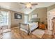Charming bedroom with hardwood floors, a ceiling fan, and a sun-filled window creating a serene atmosphere at 5045 Edinborough Pl, Sugar Hill, GA 30518