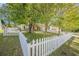 Well-maintained front yard featuring a white picket fence that enhances the property's curb appeal at 5045 Edinborough Pl, Sugar Hill, GA 30518