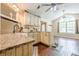 Sunlit kitchen boasts granite countertops, a farmhouse sink, custom cabinets, and hardwood floors flowing into a dining area at 5045 Edinborough Pl, Sugar Hill, GA 30518