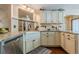 Bright kitchen featuring granite countertops, a farmhouse sink, and classic cabinetry with under cabinet lighting at 5045 Edinborough Pl, Sugar Hill, GA 30518