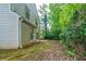 The home's backyard is framed by mature trees and lush greenery, with a small patio area at 744 Brittany Ct, Stone Mountain, GA 30083
