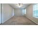 Bright bedroom features plush carpet, multiple windows, a ceiling fan, and neutral tones at 744 Brittany Ct, Stone Mountain, GA 30083