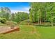 Landscaped backyard with a wooden bridge overlooking an abundant green yard at 2480 Ashbourne Dr, Lawrenceville, GA 30043