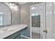 Bathroom with floral wallpaper, single sink vanity, and doorway to tiled shower at 2480 Ashbourne Dr, Lawrenceville, GA 30043