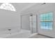 Bright bathroom features tiled shower, soaking tub, and decorative window at 2480 Ashbourne Dr, Lawrenceville, GA 30043