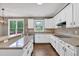 Bright kitchen boasts white cabinetry, modern appliances, and views to the outdoors at 2480 Ashbourne Dr, Lawrenceville, GA 30043