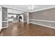 Hardwood floors in an open layout connecting the living area to a kitchen with white cabinets and appliances at 2480 Ashbourne Dr, Lawrenceville, GA 30043