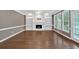Open living room featuring hardwood floors, a fireplace with built-ins, and large windows for natural light at 2480 Ashbourne Dr, Lawrenceville, GA 30043