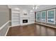 Spacious living room with hardwood floors, a fireplace, built-in shelves, and bright natural light at 2480 Ashbourne Dr, Lawrenceville, GA 30043